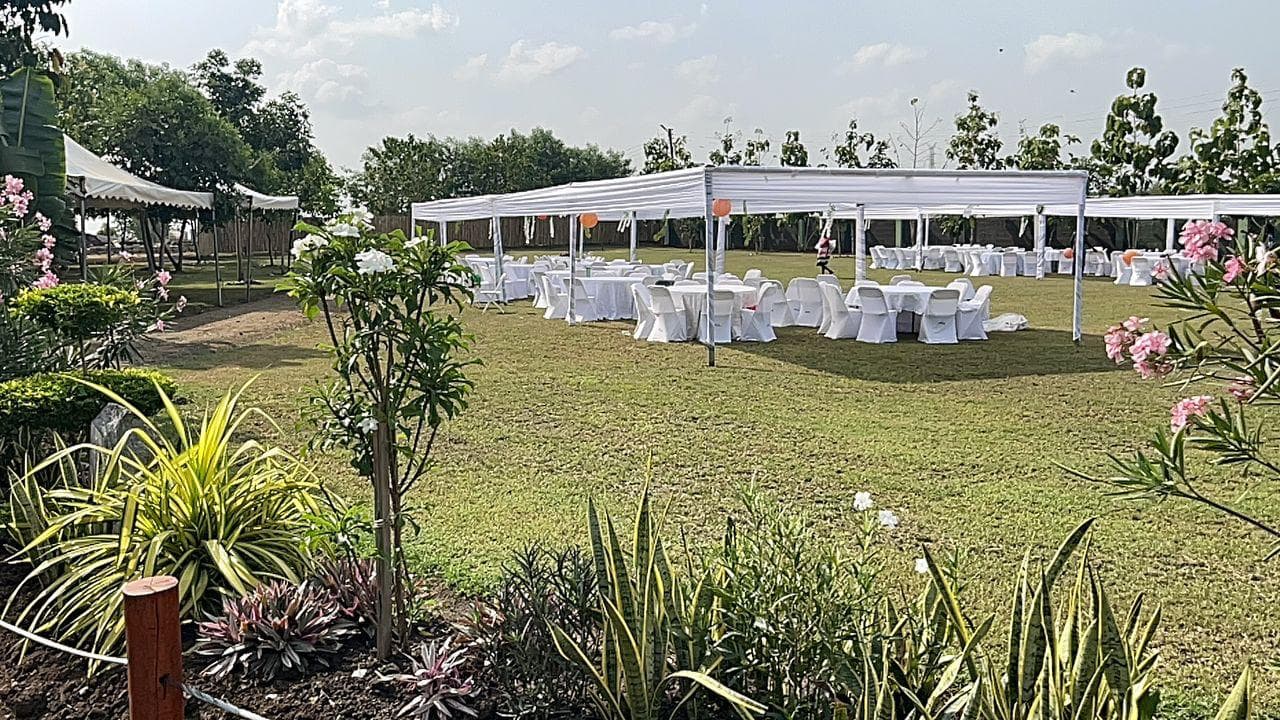 Outdoor event with white canopy tents and tables